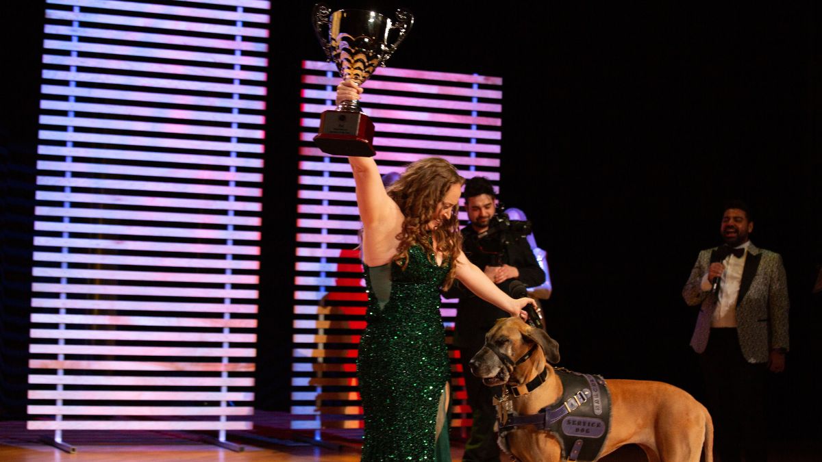 Michelle Weger, 2025 Speaker Slam® #1 Inspirational Speaker of the Year, on stage at CBC Glenn Gould Studio with her Great Dane service dog Quinn.